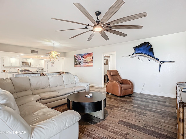 living room with an inviting chandelier and dark wood-type flooring