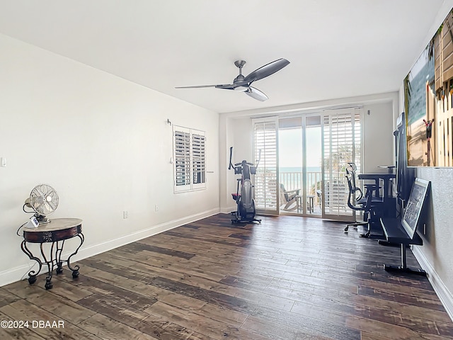 workout room with ceiling fan and dark wood-type flooring