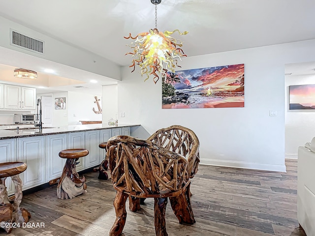 dining room with dark hardwood / wood-style flooring, an inviting chandelier, and sink