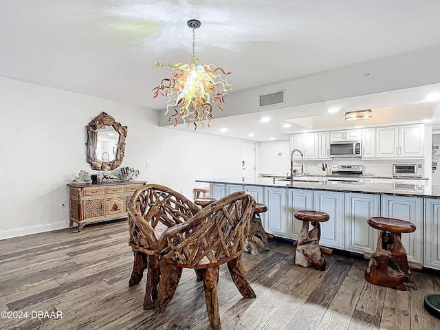 dining space with dark hardwood / wood-style flooring, a chandelier, and sink