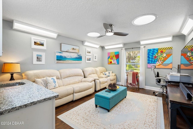 living room with dark hardwood / wood-style flooring, a textured ceiling, and ceiling fan