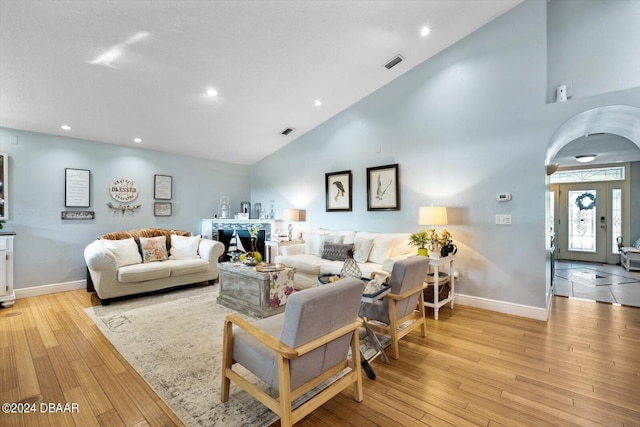 living room with light hardwood / wood-style flooring and high vaulted ceiling