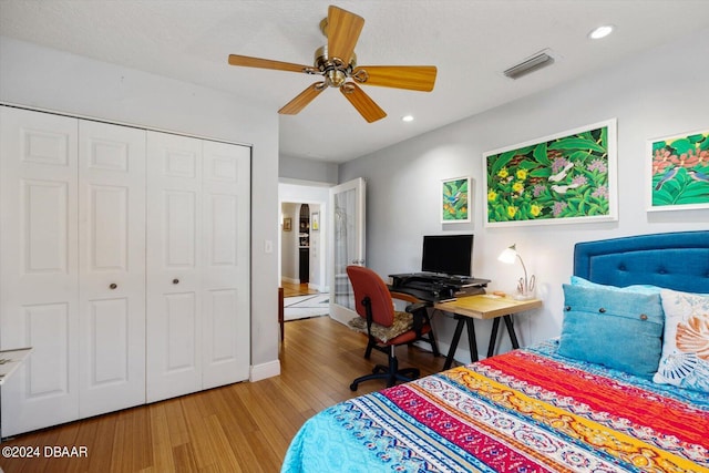 bedroom with hardwood / wood-style flooring, ceiling fan, and a closet