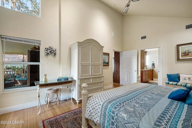 bedroom featuring wood-type flooring and high vaulted ceiling