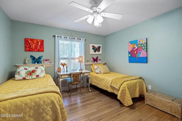 bedroom with wood-type flooring, ceiling fan, and a textured ceiling