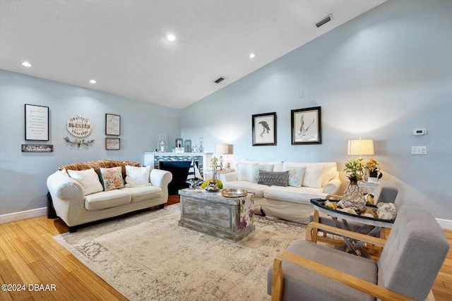 living room with light hardwood / wood-style floors and high vaulted ceiling