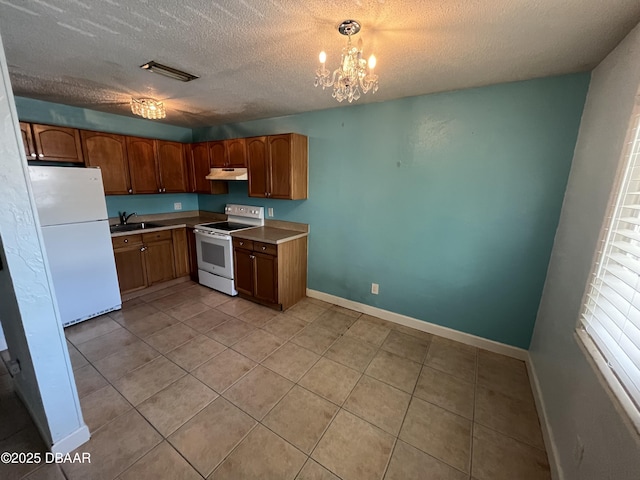 411 N Halifax Ave Unit 203, Daytona Beach, FL 32118 - kitchen with white appliances, under cabinet range hood, light tile patterned floors, a textured ceiling, and a chandelier