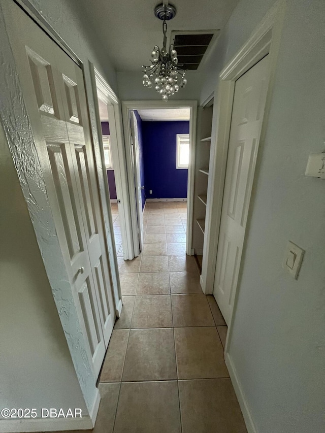411 N Halifax Ave Unit 203, Daytona Beach, FL 32118 - hallway with a chandelier and light tile patterned flooring