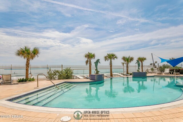 view of pool featuring a patio area and a water view