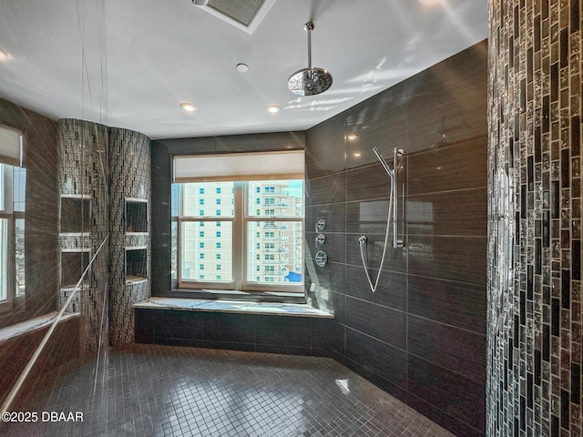 bathroom featuring tile patterned floors, tile walls, and tiled shower