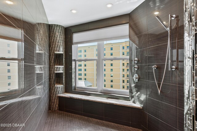 bathroom with tile patterned floors, tiled shower, and tile walls