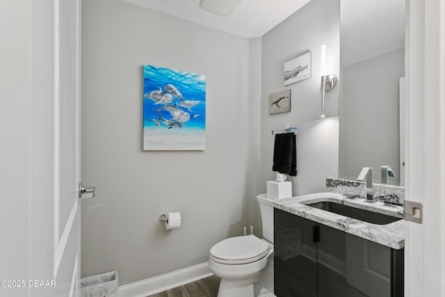 bathroom with hardwood / wood-style flooring, vanity, and toilet