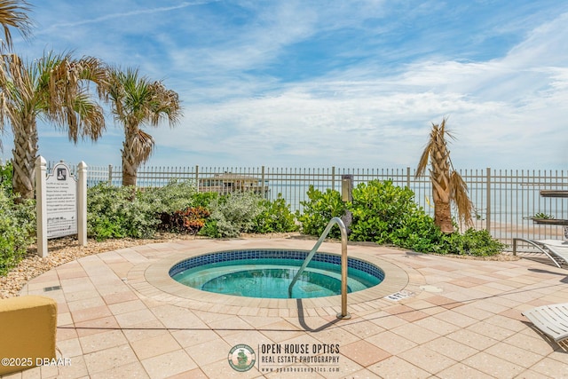 view of swimming pool featuring a community hot tub and a water view