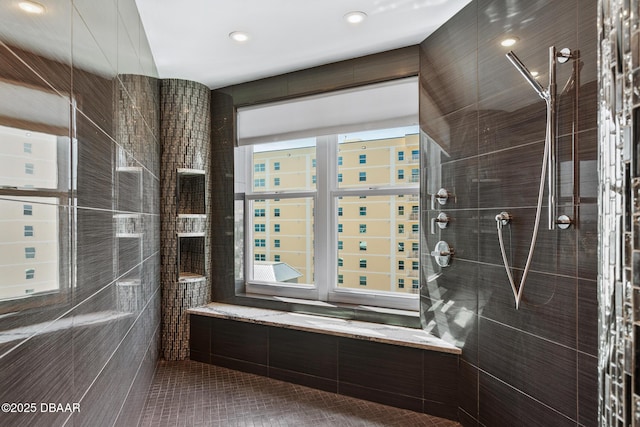 bathroom with tile patterned flooring, tiled shower, and tile walls