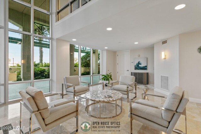 living room featuring a towering ceiling and expansive windows