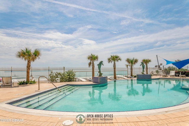 view of swimming pool with a water view and a patio