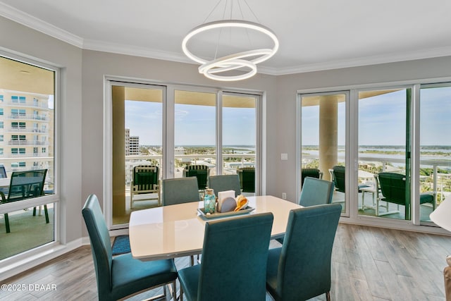 dining space with crown molding, hardwood / wood-style floors, and a notable chandelier