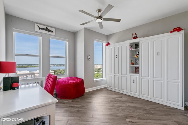 office area with hardwood / wood-style flooring, ceiling fan, and a water view