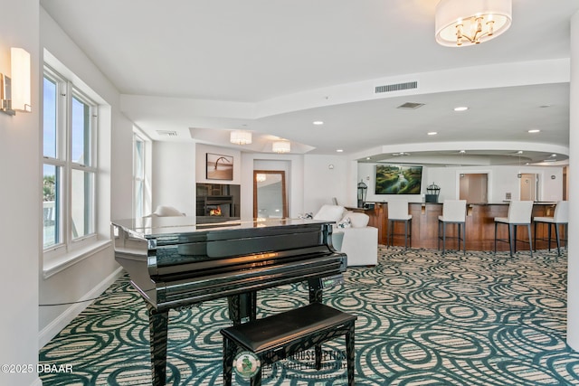 miscellaneous room featuring carpet flooring, a fireplace, and an inviting chandelier