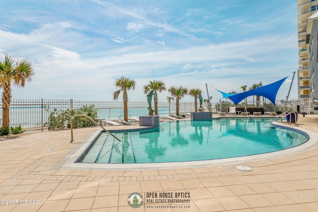 view of swimming pool with a water view and a patio area