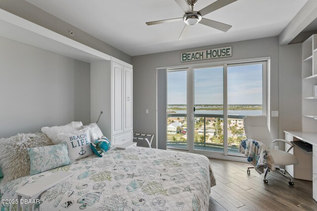 bedroom with ceiling fan, a closet, a water view, and hardwood / wood-style flooring