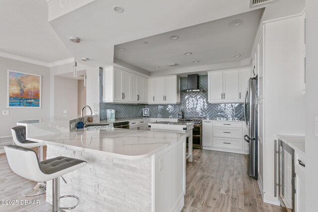 kitchen with a kitchen bar, sink, white cabinets, and appliances with stainless steel finishes