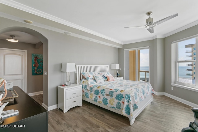 bedroom featuring ceiling fan, crown molding, a water view, and wood-type flooring