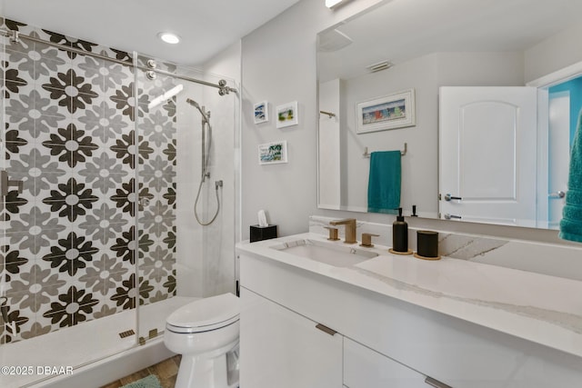 bathroom featuring tiled shower, vanity, and toilet