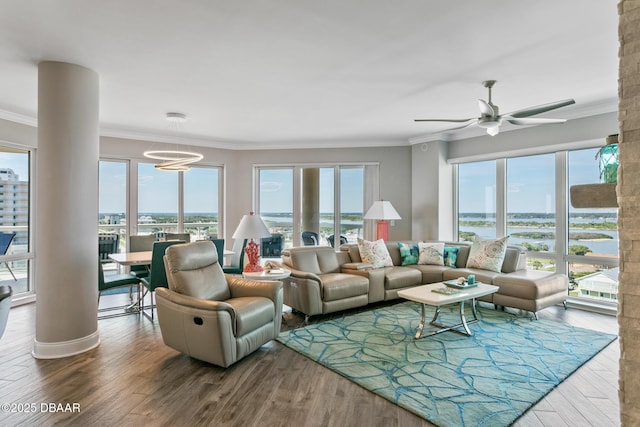 living room with hardwood / wood-style flooring, ceiling fan, ornamental molding, and a water view