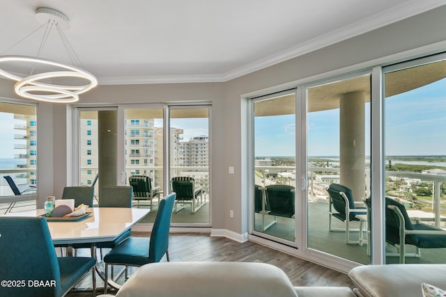 dining space with wood-type flooring, crown molding, and a chandelier