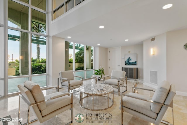 living room with a towering ceiling and expansive windows