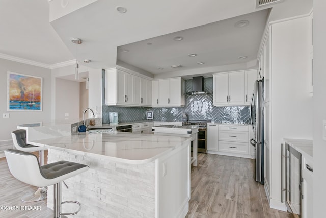 kitchen with a kitchen bar, white cabinetry, sink, and stainless steel appliances