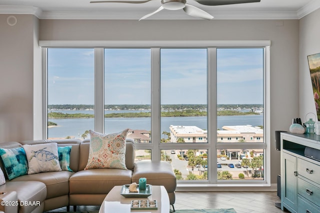 living room with a wealth of natural light, crown molding, a water view, and light hardwood / wood-style flooring