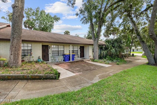 view of front of home featuring roof with shingles and brick siding