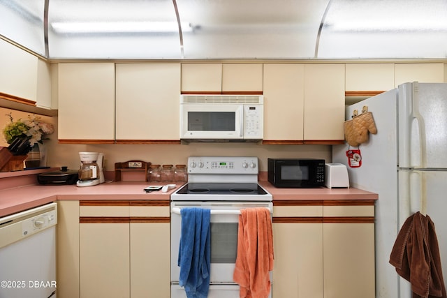 kitchen with cream cabinetry and white appliances