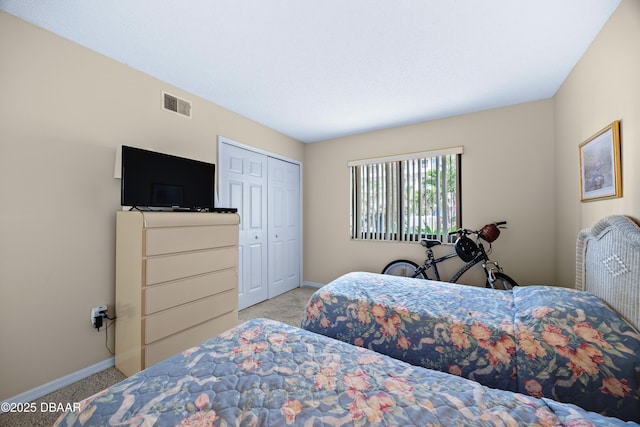 bedroom featuring a closet and light colored carpet