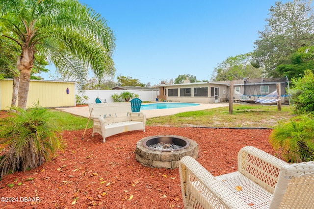 view of pool with an outdoor structure, a fire pit, and a patio area