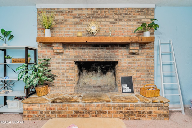 interior details with a brick fireplace, a textured ceiling, and carpet floors