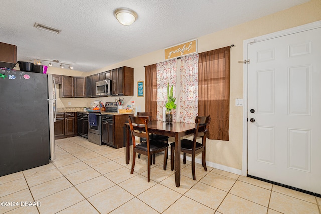 tiled dining space with a textured ceiling