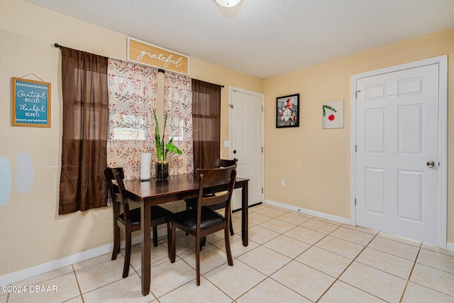 tiled dining room with a textured ceiling