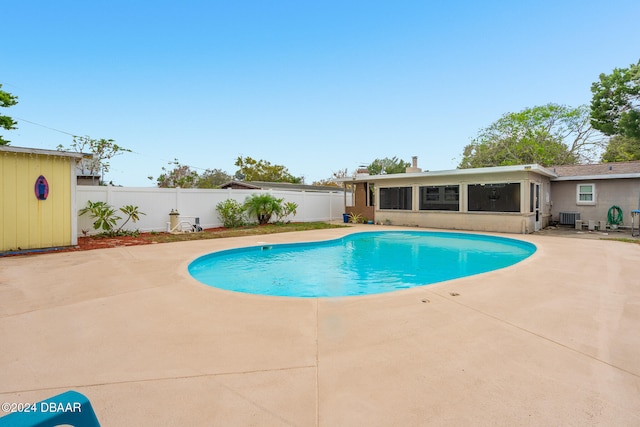 view of swimming pool with central AC unit and a patio area