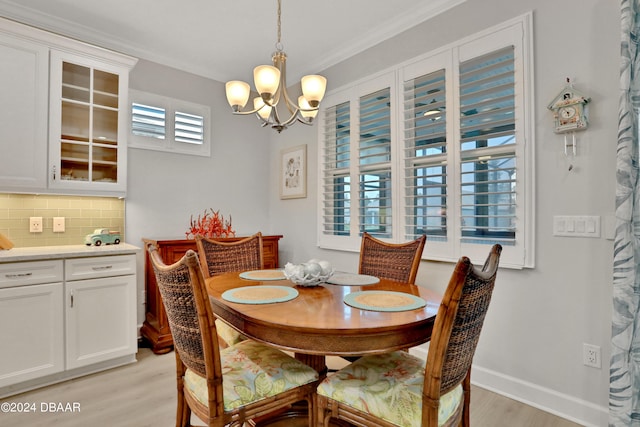 dining space with light hardwood / wood-style floors, a notable chandelier, and crown molding