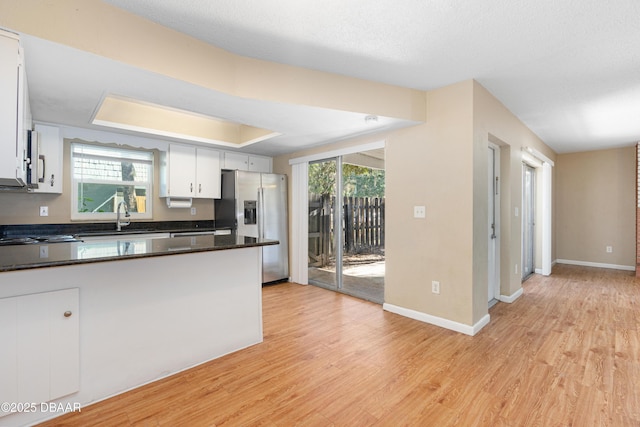 kitchen featuring stainless steel refrigerator with ice dispenser, sink, white cabinets, and light hardwood / wood-style floors