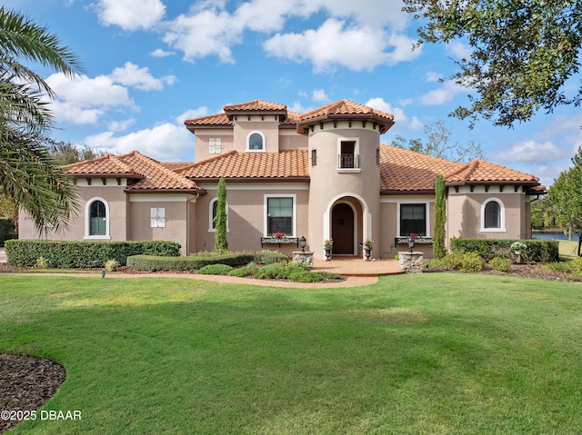 mediterranean / spanish home featuring a front lawn