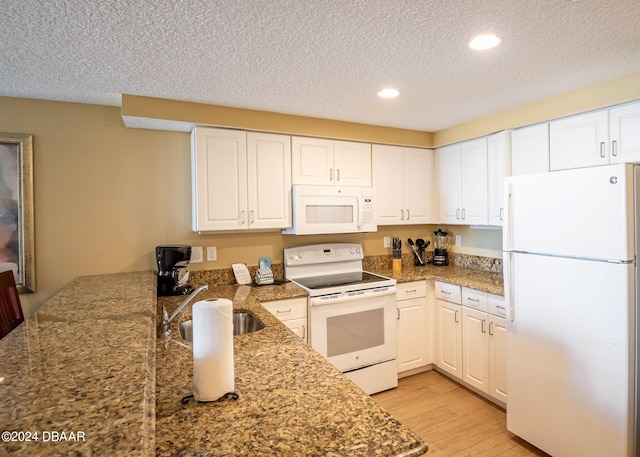 kitchen featuring white cabinets, white appliances, a textured ceiling, and light wood-style floors