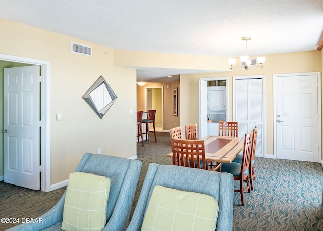 carpeted dining room featuring visible vents, baseboards, a textured ceiling, and a chandelier