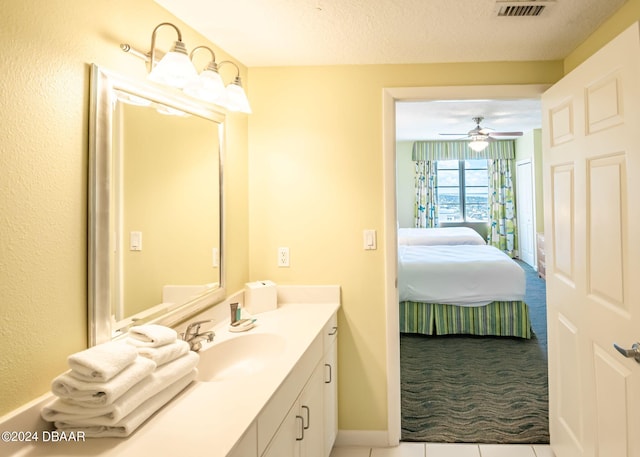 bathroom with tile patterned flooring, visible vents, vanity, ensuite bath, and a textured ceiling