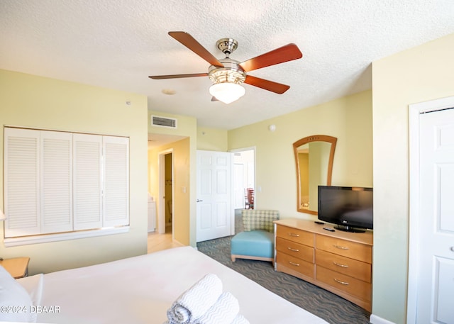 bedroom with dark colored carpet, visible vents, a textured ceiling, and ceiling fan