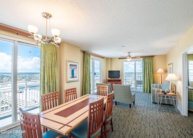 carpeted dining space featuring ceiling fan with notable chandelier and a textured ceiling