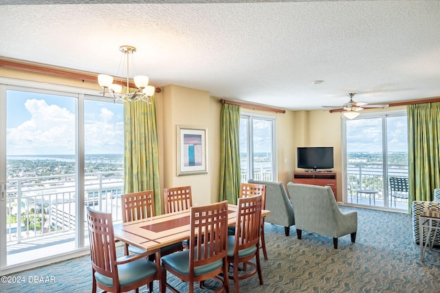 carpeted dining room with ceiling fan with notable chandelier and a textured ceiling